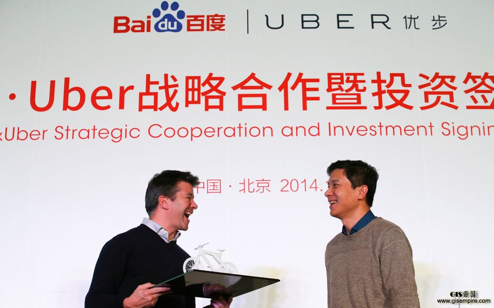 Uber CEO Kalanick smiles after receiving a gift from Baidu Inc. Chairman and CEO Li during the Baidu and Uber strategic cooperation and investment signing ceremony in Beijing